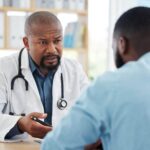 Médecin expliquant les résultats d’un test de paludisme à un patient en consultation après analyses sanguines en laboratoire