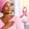 Femme africaine vêtue de rose avec un ruban rose symbolisant la sensibilisation au cancer du sein.